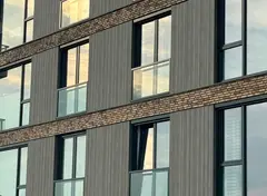 Modern gebouw met gevel van baksteen en grijze panelen.