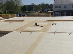 Houten vloer met gemonteerde platen en gereedschap op het oppervlak.