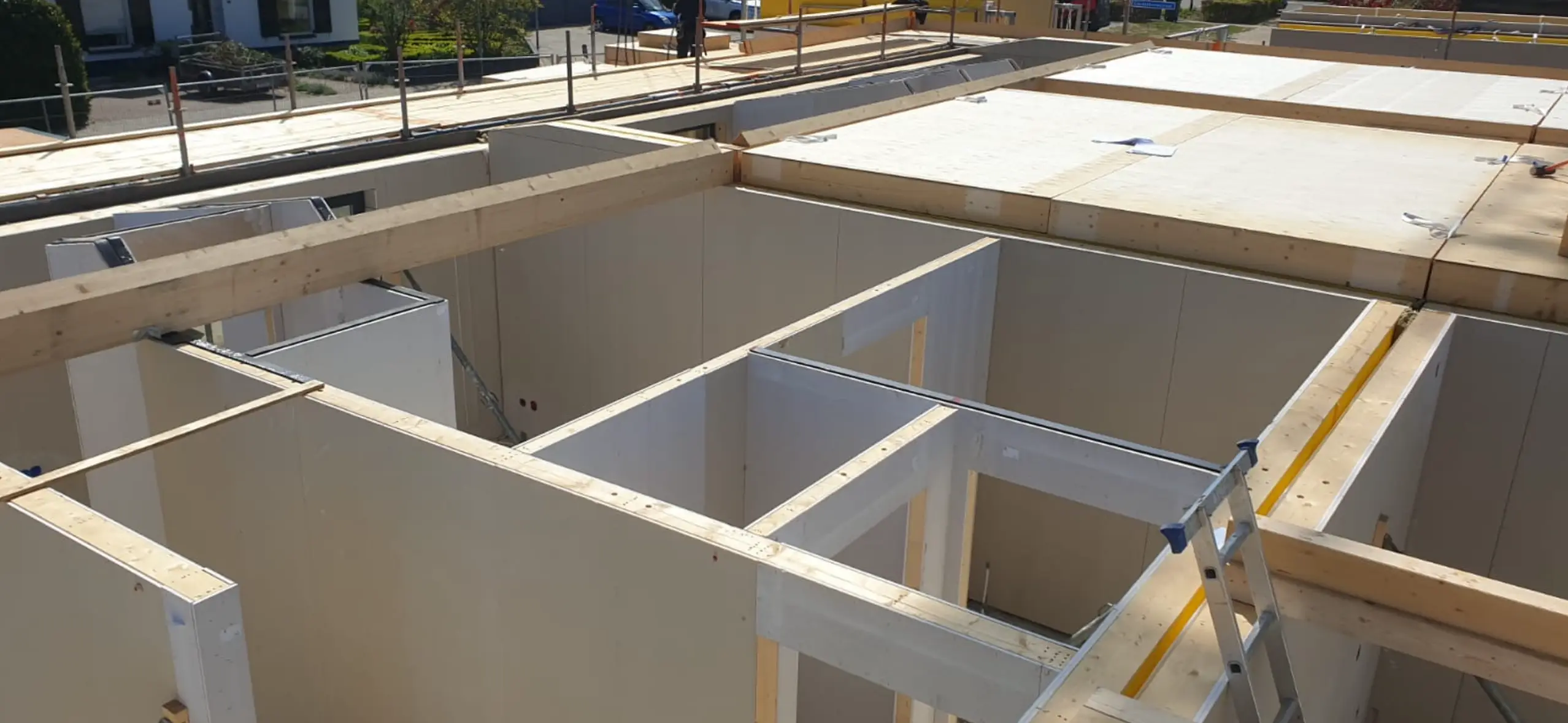 Bovenaanzicht van montage van een vloer met houten balken en constructieplaten.